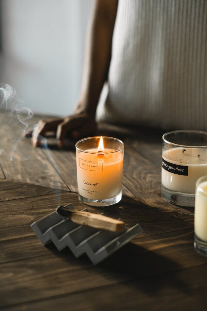 crop black woman standing at table with aromatic palo santo stick