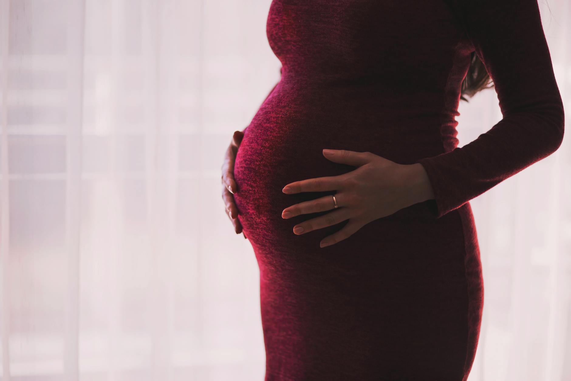 pregnant woman holding her baby bump