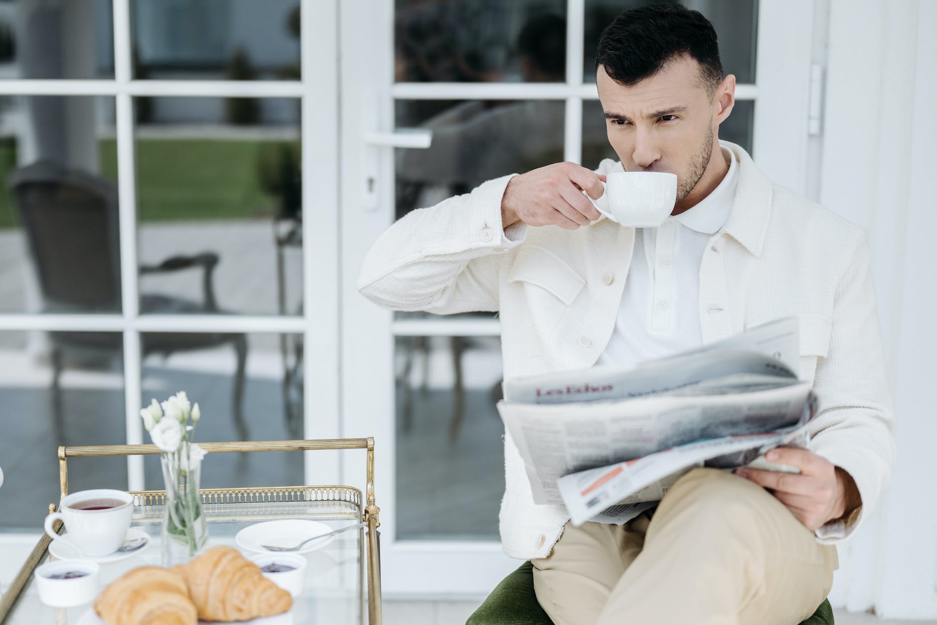 a man in white long sleeves drinking from white ceramic mug