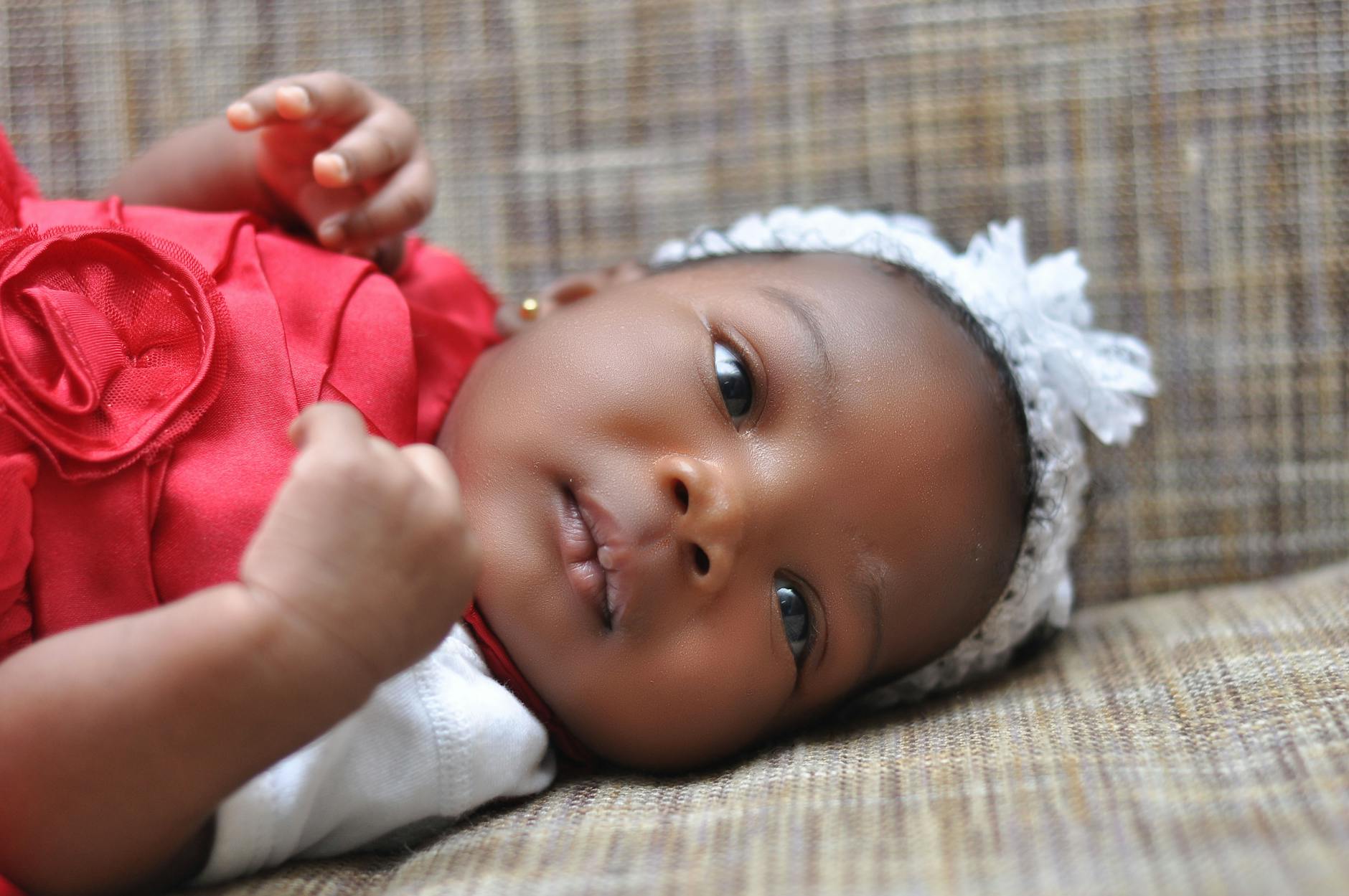 baby lying on brown cushion